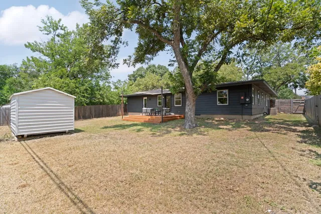 a backyard of a house with white floor and tree