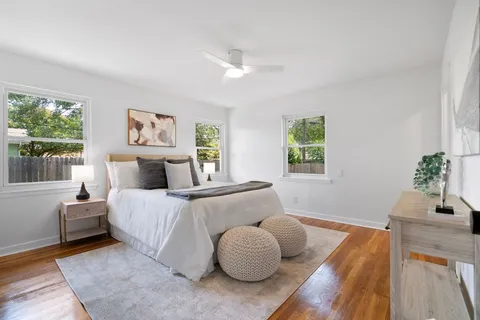 a bedroom with bed and wooden floor