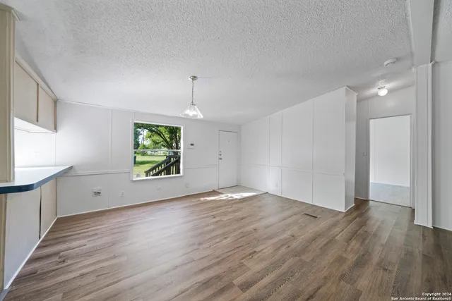 an empty room with window and wooden floor
