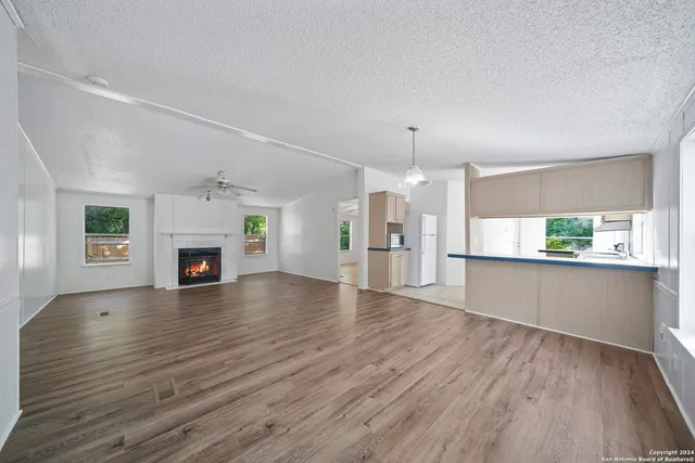 a view of empty room with wooden floor and fireplace