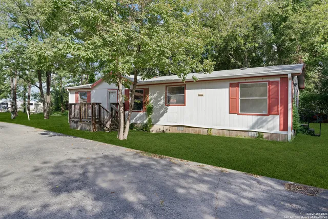 a view of a house with backyard and a tree