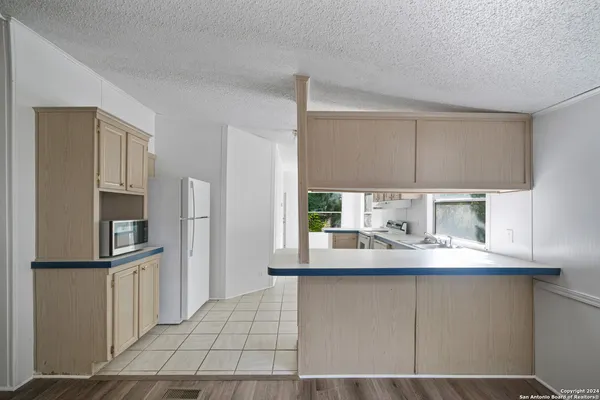 a kitchen with kitchen island granite countertop a sink cabinets and stainless steel appliances