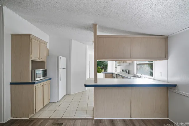 a kitchen with kitchen island granite countertop a sink cabinets and stainless steel appliances