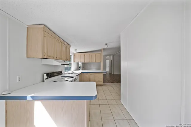 a kitchen with a sink a stove and white cabinets