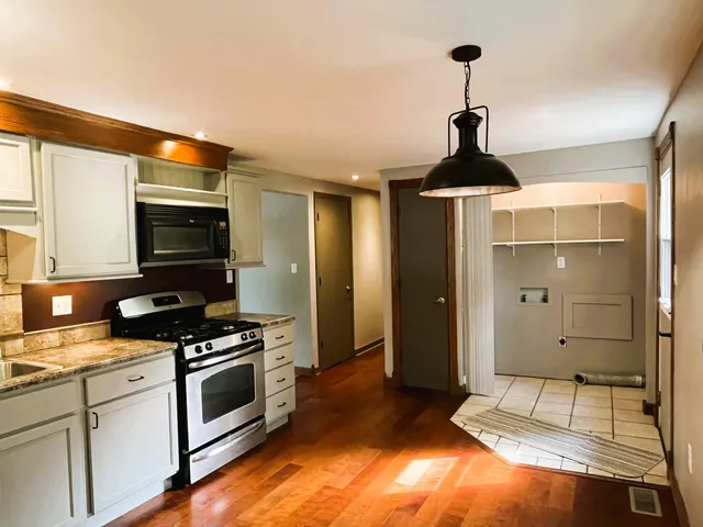 a kitchen with granite countertop a sink and a stove