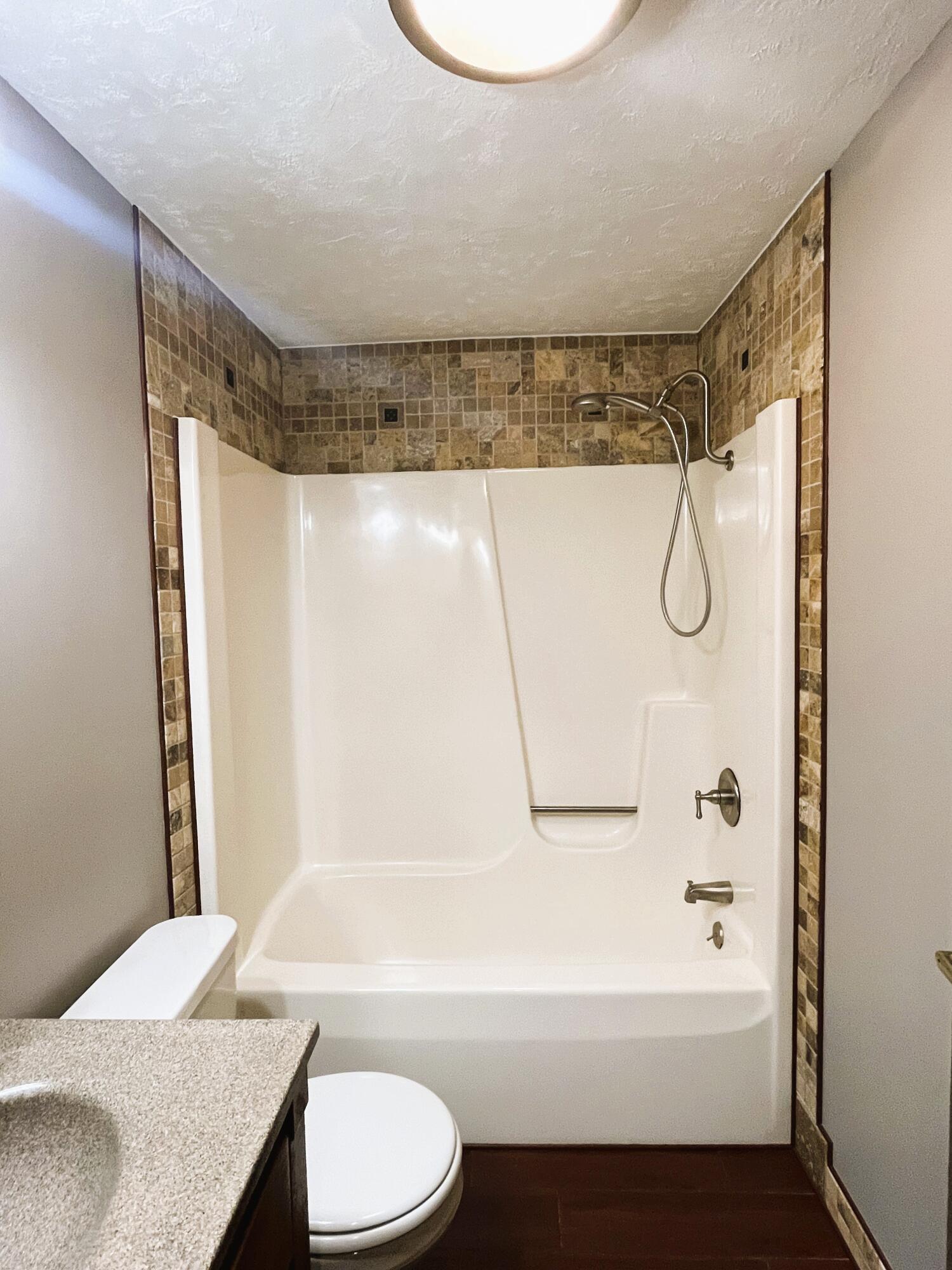 821 East Merritt Street Rensselaer, IN 47978 - Photo 14 of 18 a bathroom with a granite countertop bathtub shower sink vanity and toilet