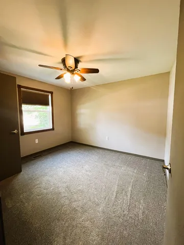 a view of an empty room with a ceiling fan