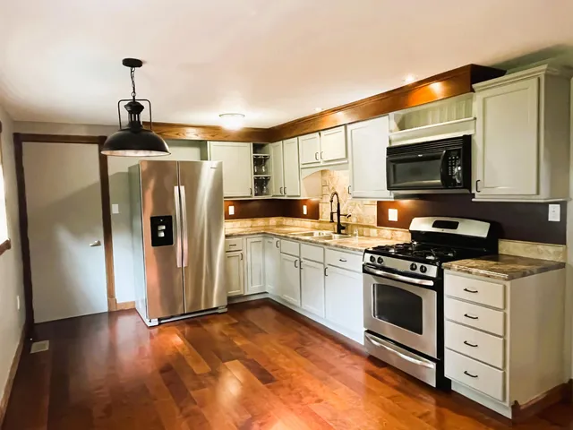 a kitchen with granite countertop a stove and a refrigerator