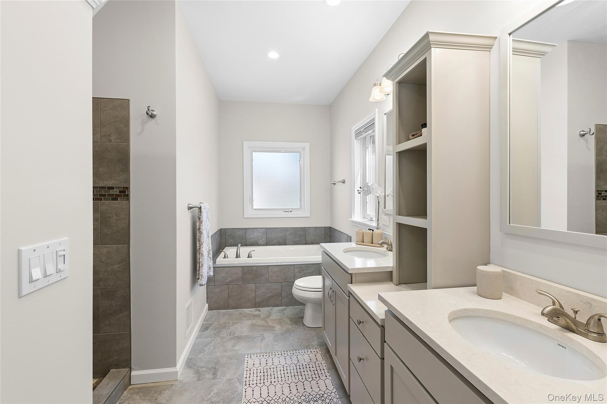 2280 Deep Hole Drive Mattituck, NY 11952 - Photo 14 of 35 Full bath featuring two vanities, a bath, and exquisitely tiled shower