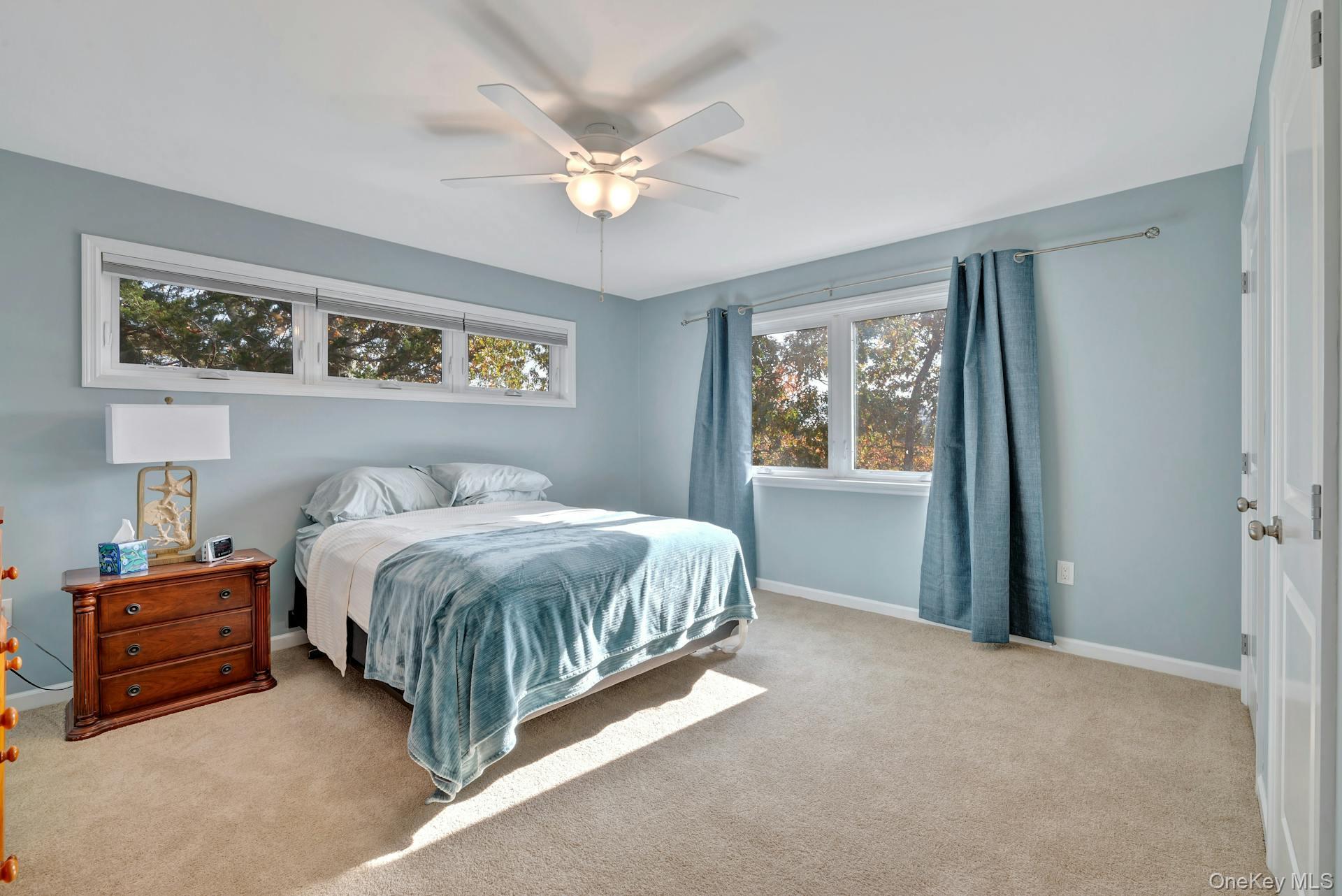 2280 Deep Hole Drive Mattituck, NY 11952 - Photo 21 of 41 a spacious bedroom with a bed and a chandelier
