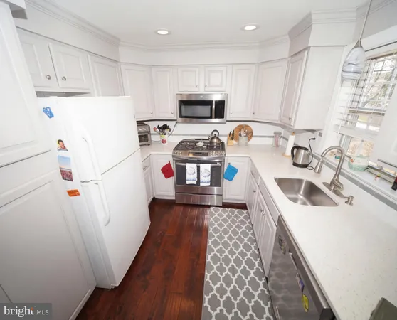a kitchen with a sink a stove a refrigerator and cabinets