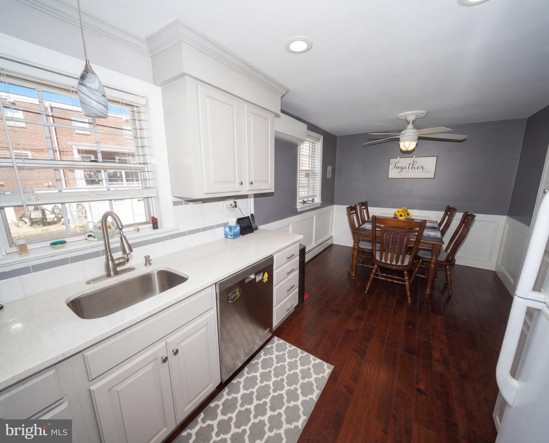 3216 Chesterfield Road Philadelphia, PA 19114 - Photo 13 of 27 a kitchen with stainless steel appliances granite countertop a sink dishwasher a stove a dining table and chairs with wooden floor