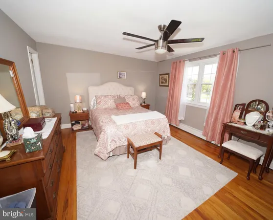 a bedroom with a bed and a dresser next to a window