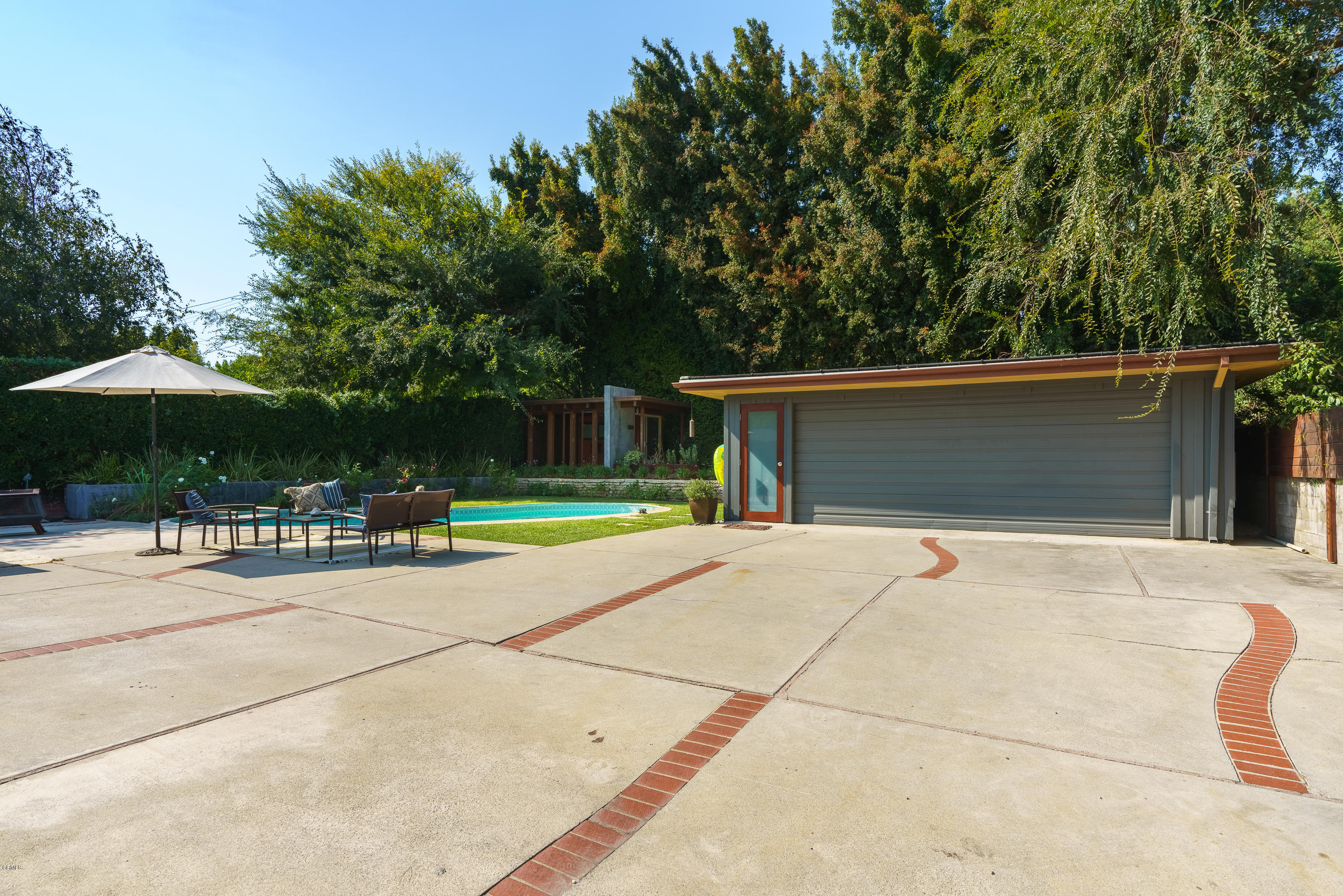 1025 Nithsdale Road Pasadena, CA 91105 - Photo 33 of 34 a backyard of a house with table and chairs under an umbrella