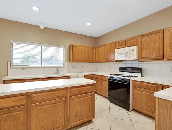 a kitchen with a stove top oven and cabinets