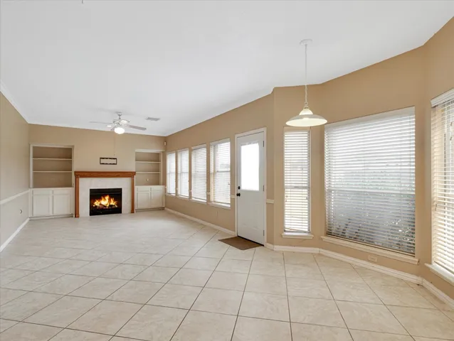 an empty room with windows and fireplace