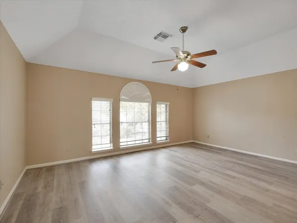 a view of empty room with wooden floor