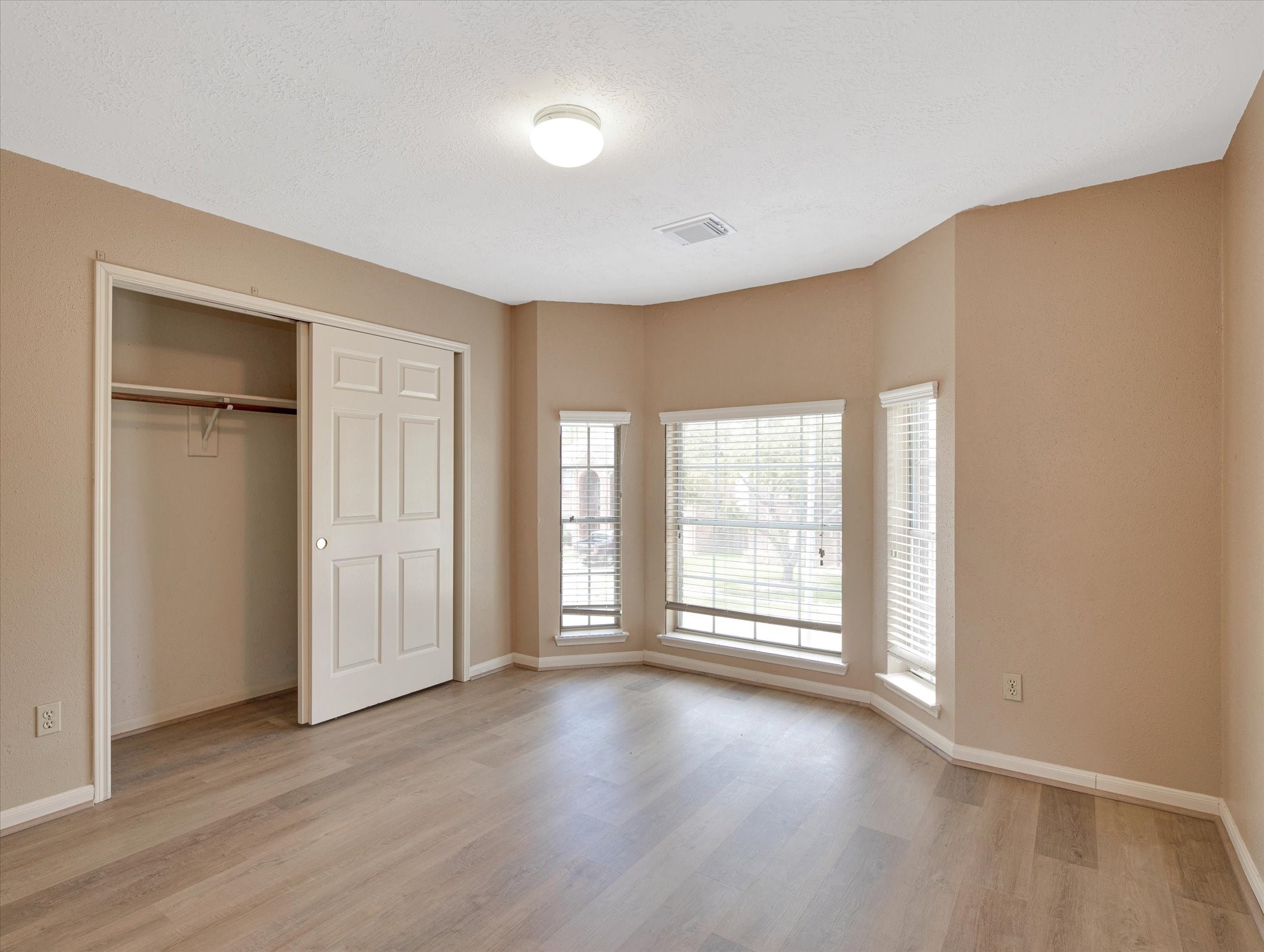 16423 Ash Point Lane Sugar Land, TX 77498 - Photo 40 of 46 an empty room with wooden floor and windows with curtains