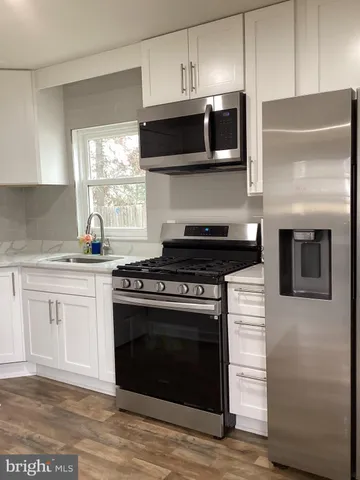 a kitchen with stainless steel appliances a stove a sink and a microwave
