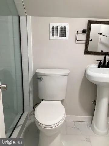 a white toilet sitting next to a bathroom sink