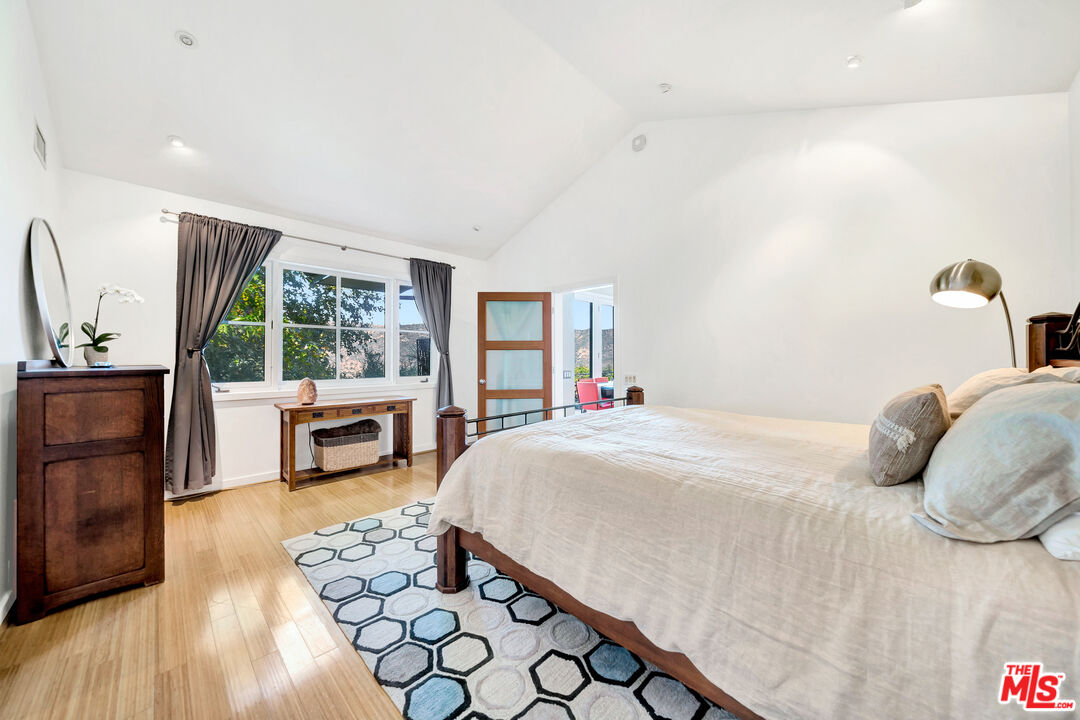 26227 Fairside Road Malibu, CA 90265 - Photo 13 of 30 a bedroom with furniture a fireplace and large windows