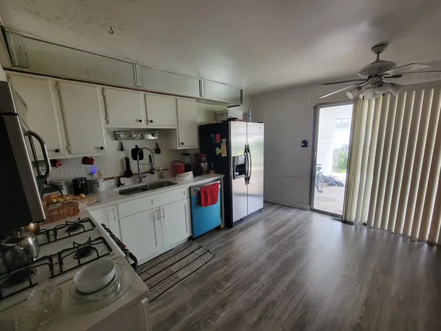 a kitchen with sink a refrigerator and wooden floor