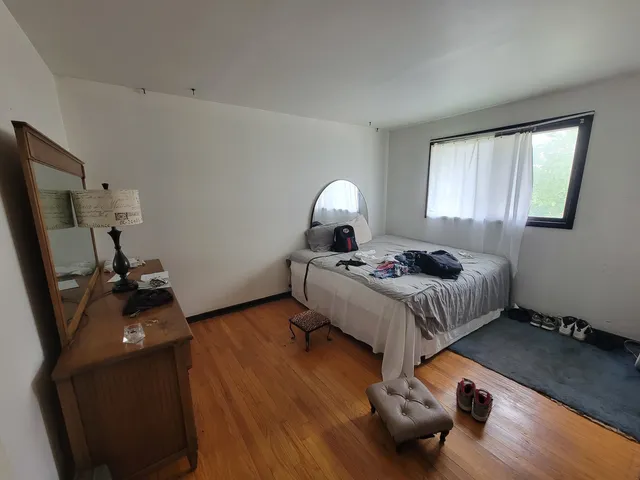 a bedroom with a bed and a wooden floor