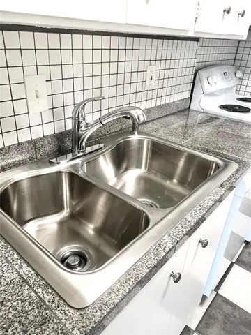 a close view of sink a faucet a washer and dryer