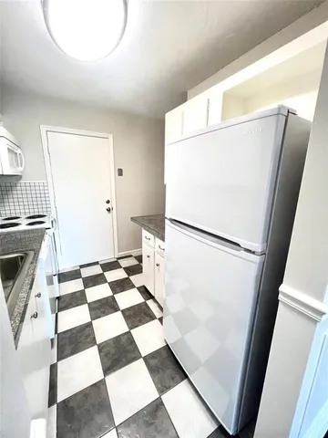 a walk in closet with wooden floor and a black gate