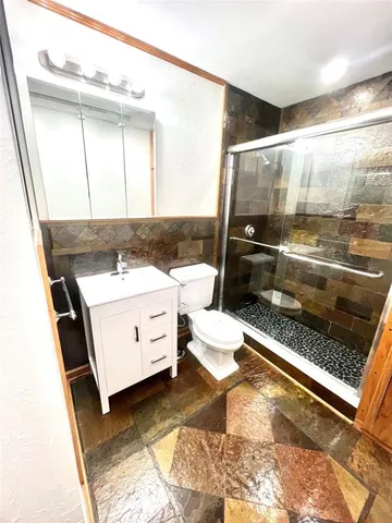 a bathroom with a sink a toilet and shower