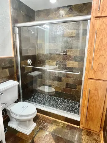 a bathroom with a toilet and a shower