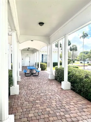 a view of a fountain in the backyard of house along with trees