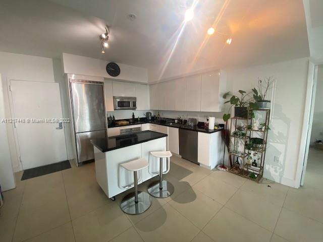 92 Southwest 3rd Street, Unit 1412 Miami, FL 33130 - Photo 2 of 37 a kitchen with cabinets and stainless steel appliances