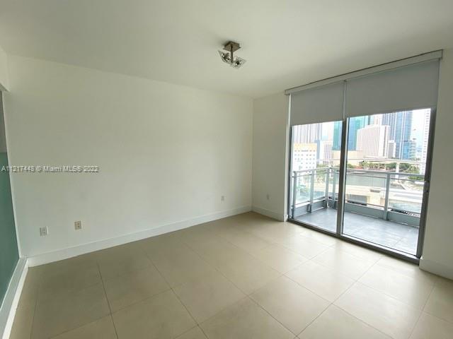 92 Southwest 3rd Street, Unit 1412 Miami, FL 33130 - Photo 6 of 37 an empty room with sliding glass door and windows