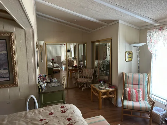 a bedroom with a bed a mirror and a potted plant