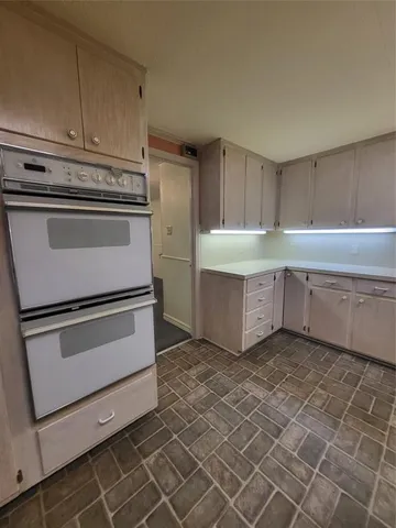 a kitchen with white cabinets and white appliances
