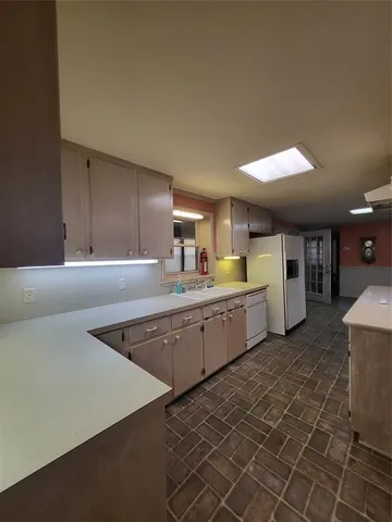 a large kitchen with kitchen island a sink stainless steel appliances and cabinets