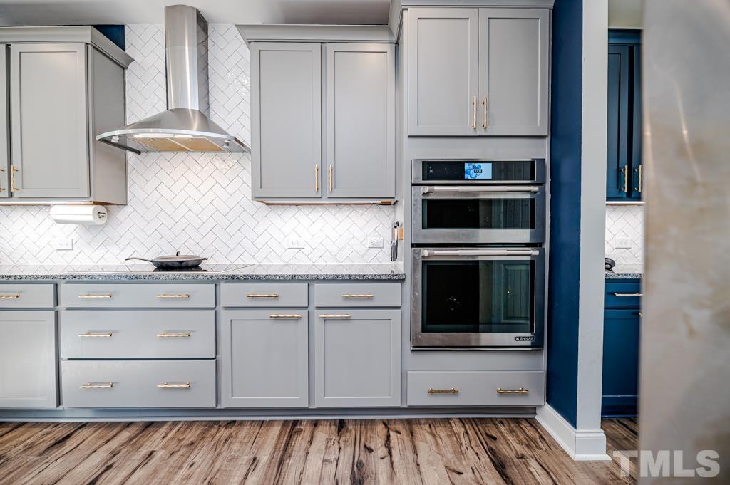 6712 Lucado Court Raleigh, NC 27603 - Photo 13 of 52 a kitchen with granite countertop white cabinets and stainless steel appliances