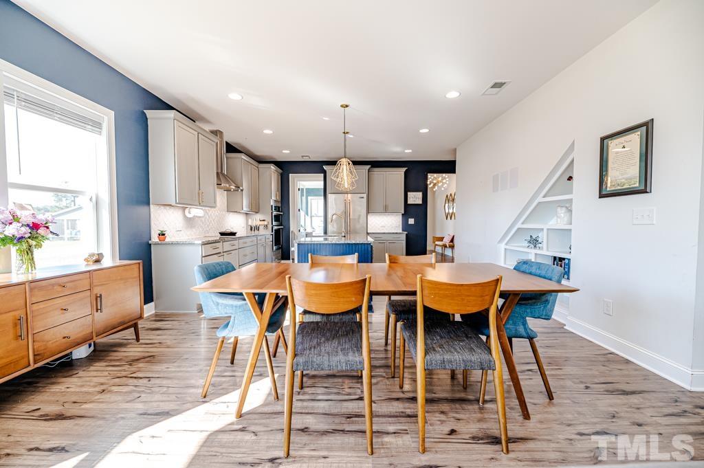 6712 Lucado Court Raleigh, NC 27603 - Photo 18 of 52 a dining room with stainless steel appliances kitchen island granite countertop wooden floor view and a window