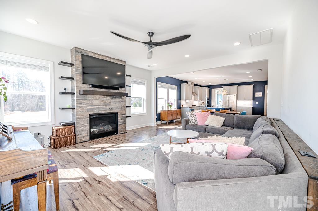6712 Lucado Court Raleigh, NC 27603 - Photo 20 of 52 a living room with furniture a flat screen tv and a fireplace