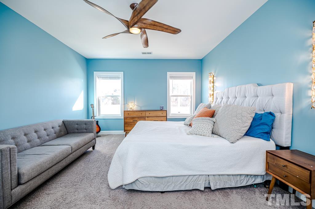 6712 Lucado Court Raleigh, NC 27603 - Photo 23 of 52 a bedroom with a bed couch and window