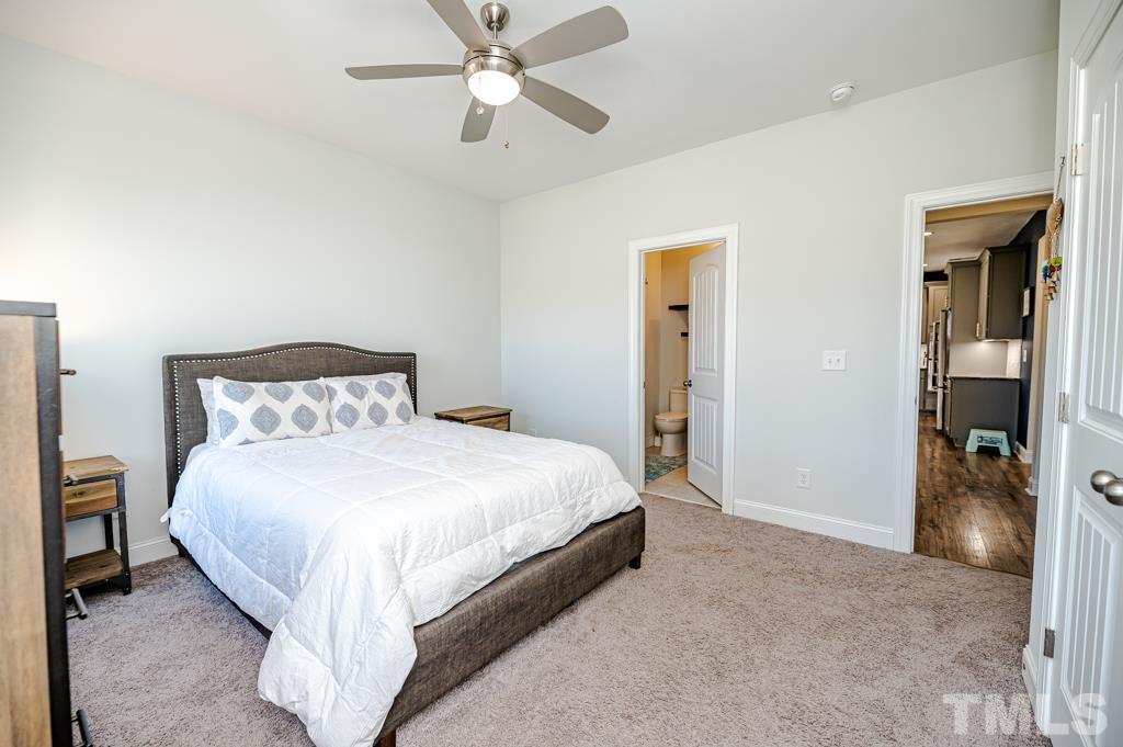 6712 Lucado Court Raleigh, NC 27603 - Photo 31 of 52 a spacious bedroom with a bed and a chandelier