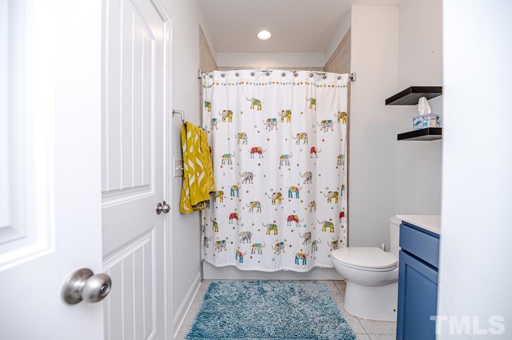 6712 Lucado Court Raleigh, NC 27603 - Photo 32 of 52 a bathroom with a toilet and shower curtain