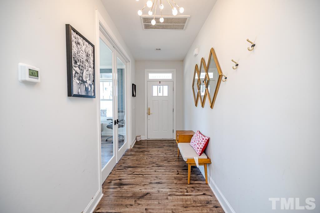 6712 Lucado Court Raleigh, NC 27603 - Photo 6 of 52 a hallway with a large mirror and a potted plant