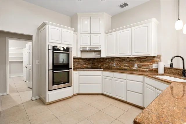 a kitchen with cabinets and stainless steel appliances