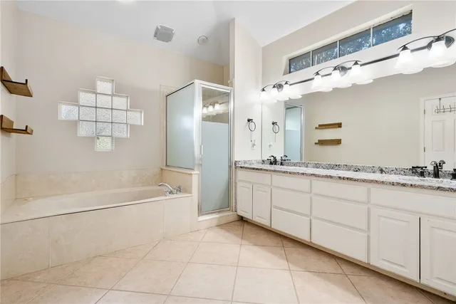 a bathroom with a granite countertop sink a mirror and a bathtub