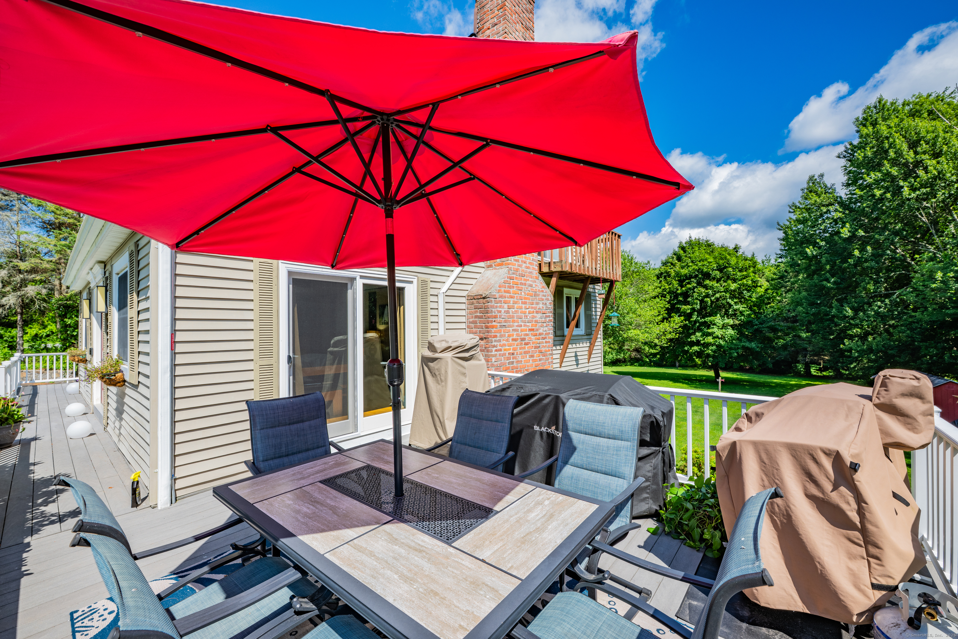 21 Long Meadow Road Bethlehem, CT 06751 - Photo 12 of 32 a patio with a table and chairs under an umbrella