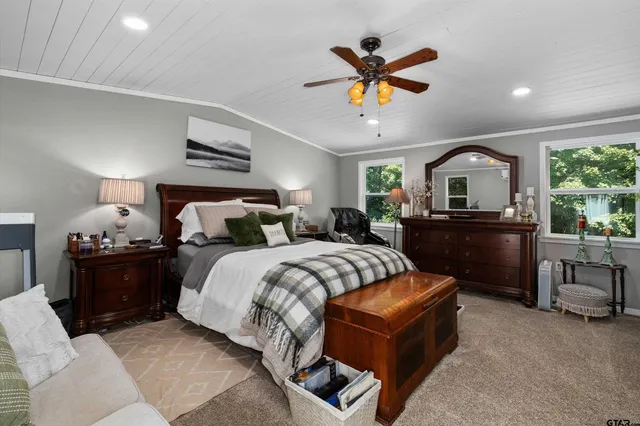 a spacious bedroom with a bed and a flat screen tv