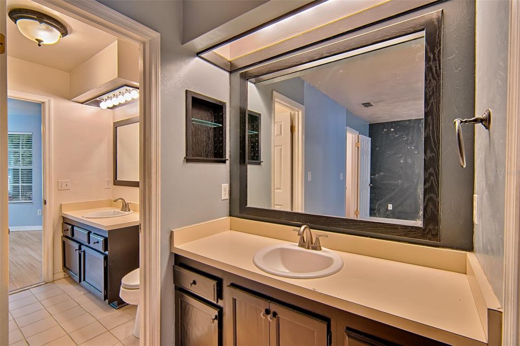 2305 Southwest 73rd Terrace Gainesville, FL 32607 - Photo 14 of 21 a bathroom with a granite countertop sink and a mirror