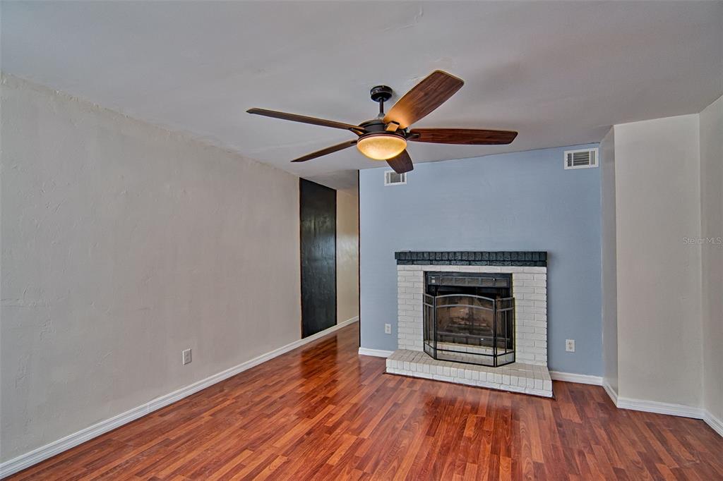 2305 Southwest 73rd Terrace Gainesville, FL 32607 - Photo 2 of 21 a view of an empty room with wooden floor and a fireplace